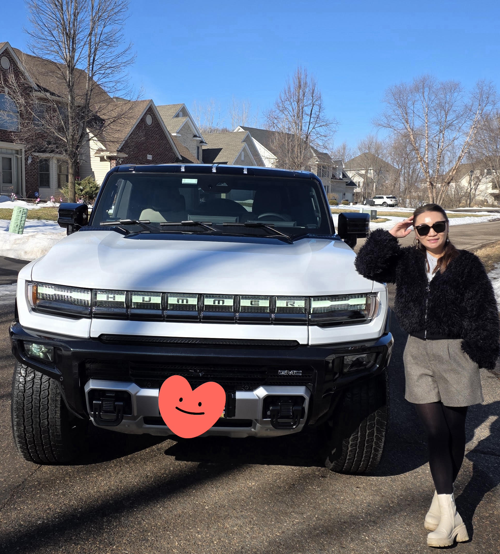 Guest standing beside the front of the white HUMMER EV