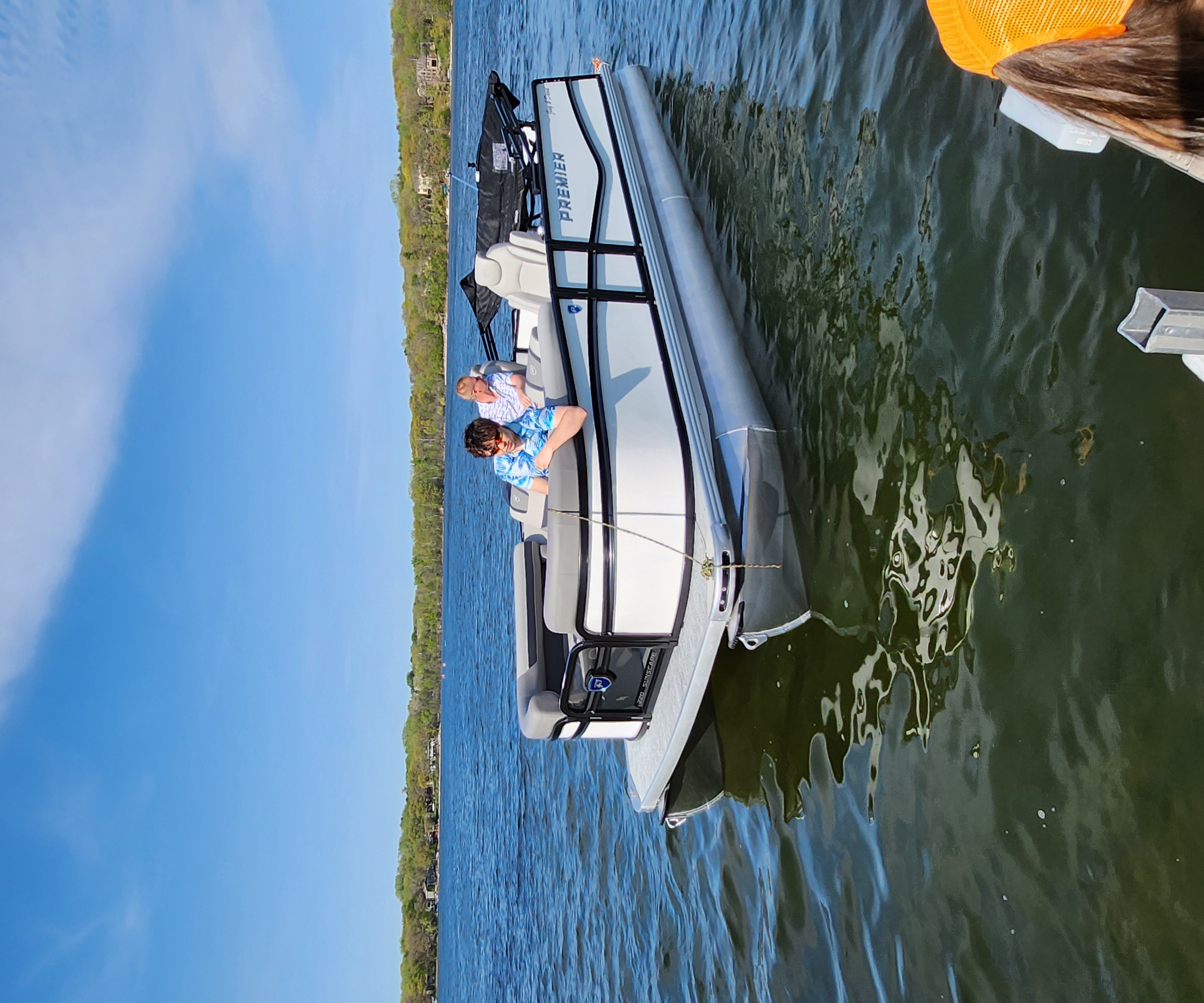 White Premier pontoon with gray seating on the lake